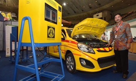 Kepala Laboratorium Teknik Kendali Fakultas Teknik Universitas Indonesia (UI) Feri Yusivar berpose di depan mobil listrik hasil inovasi dan karya dari dosen dan mahasiswa UI yang dipamerkan pada acara Seminar dan Pameran Ketenagalistrikan di Jakarta 