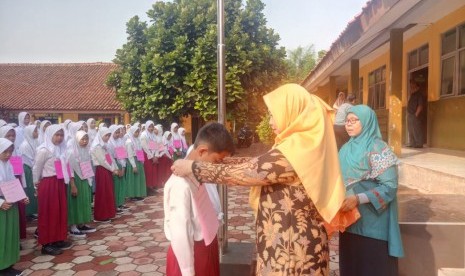 Kepala MTsN 1 Bogor, Etty Munyati menyematkan tanda peserta kepada siswa baru peserta Masa Ta