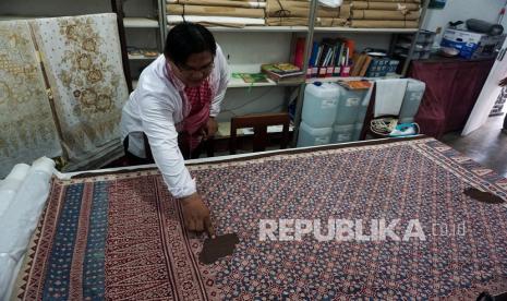 Kepala Museum Batik Akhmad Asror mengamati koleksi Batik Jlamprang di Museum Batik Pekalongan, Jawa Tengah, Selasa (1/3/2022). Menurut pihak museum, kain batik tulis bermotif Jlamprang khas Pekalongan itu merupakan salah satu aset kain batik berusia sekitar 1 abad yang dibuat sekitar tahun 1900. dan saat ini menjadi salah satu koleksi kain batik kuno di museum. 