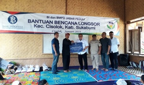 Kepala Perwakilan Bank Indonesia Provinsi Jawa Barat Doni P Joewono menyerahkan bantuan kepada korban longsor di Desa Sirna Res Kecamatan Cisolok, Kabupaten Sukabumi Selasa (8/1). Bantuan diterima oleh ketua atau pemangku adat Kasepuhan Adat Sinar Resmi Abah Asep Nugraha.