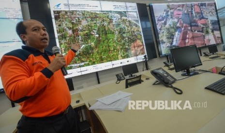 Kepala Pusat Data, Informasi, dan Humas Badan Penanggulangan Bencana (BNPB) Sutopo Purwo Nugroho lokasi bencana gempa di Provinci Aceh melalui layar di ruang pemantauan bencana Gedung BNPB, Jakarta, Jumat (9/12). 