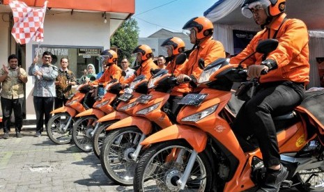   Kepala Regional 7 Jawa Timur Arifin Muchlis (memegang bendera) meresmikan aplikasi COD Pos yang ditandai dengan memberangkatkan para pengantar Pos di Kantor Pos Jombang, Jumat (26/7).