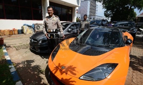 Kepala Satuan Lalu Lintas (Kasat Lantas) Polres Jakarta Utara, AKBP Sudharmanto menunjukan plat nomor palsu dari mobil mewah yang telah diamankan di kantor Samsat Jakarta Utara, Kamis (28/5). (Republika/Raisan Al Farisi)