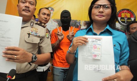 Kepala Satuan Narkoba Polres Jakarta Selatan, Vivick Tjangkung (kanan) bersama Kasubag Humas Polres Metro Jakarta Selatan Kompol Purwanta (kiri) menunjukan barang bukti berupa hasil tes urin milik Artis Tora Sudiro (tengah) saat menggelar konferensi pers terkait penggunaan dan kepemilikan obat keras Dumolid di Polres Jakarta Selatan, Jakarta, Jumat (4/8). 