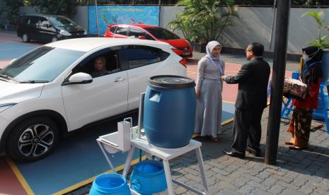 Kepala Sekolah melakukan wisuda kelulusan sekolah secara Drive Thru di Madrasah Aliyah Annajah, Ciledug Raya.