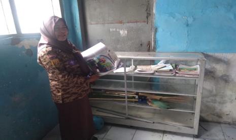 Kepala Sekolah SDN 2 Cadangpinggan, Kecamatan Sukagumiwang, Kabupaten Indramayu, Neneng Juaningsih, menunjukkan contoh buku paket pelajaran yang hilang, Senin (26/12/2022). Ada sekitar 1.300 buku paket pelajaran di sekolah itu yang hilang digondol pencuri. (