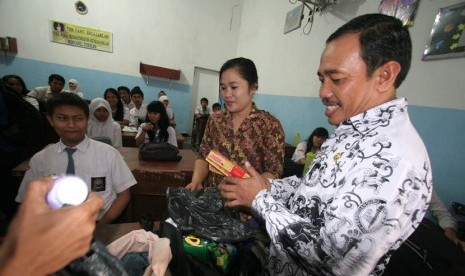  Kepala Sekolah SMA Negeri 5, Sutrisno menyita coklat dari tas milik siswa saat merazia kado Valentine di Medan, Sumut, Kamis (14/2).  (Antara/Septianda Perdana)