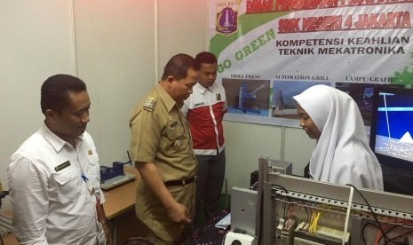 Kepala Sekolah SMK Negeri 4 Jakarta, Diding Wahyudin mendampingi Wakil Walikota Jakarta Utara, Ali Maulana Hakim, pada perhelatan open house SMK Negeri 4 Jakarta Utara.