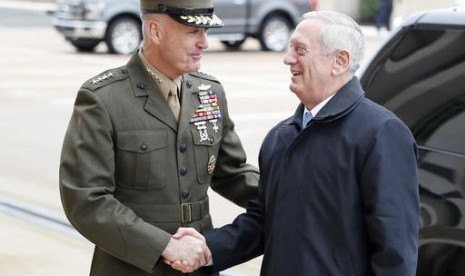 Kepala Staf Gabungan Jenderal Joseph Dunford (kiri) berjabat tangan dengan Menteri Pertahanan baru AS James Mattis saat tiba di Pentagon, Washington, Sabtu, 21 Januari 2017.