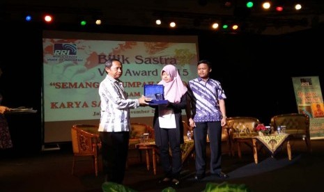 Kepala Stasiun Luar Negeri LPP RRI Eddy Sukmana menyerahkan penghargaan Bilik Sastra Award 2015 kepada pemenang pertama, Susana Nisa, disaksikan pemenang kedua, Agus Purwanto, di Jakarta, Ahad (1/11).