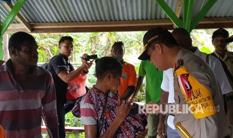 Kepolisian menyusuri korban-korban penyakit Campak di Kabupaten Asmat, Papua. 