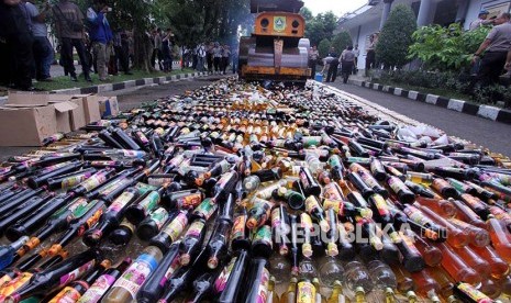 Kepolisian Polres Bogor menggunakan alat berat untuk memusnahkan sejumlah minuman keras di Mapolres Bogor,  Cibinong, Kabupaten Bogor, Jawa Barat, Selasa (13/6). Hasil operasi Pekat yang dilakukan Polres Bogor selama dua pekan bulan Ramadan berhasil mengamankan 12 ribu botol miras dari berbagai jenis serta 29 ribu petasan, hal itu dilakukan untuk menciptakan keamanan dan ketertiban pada bulan suci Ramadan.