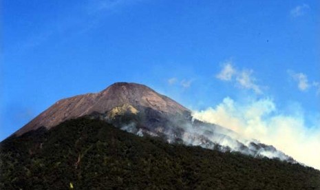   Kepulan asap dari kawasan hutan lereng Gunung Slamet yang terbakar, terlihat dari pos pendakian jalur Bambangan, Desa Kutabawa, Karangreja, Purbalingga, Ahad (26/8). 