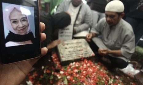 Kerabat berdoa di pusaran makam Penyanyi Laila Sari di TPU Karet Bivak, Jakarta, Selasa (21/11).