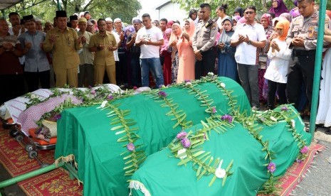 Kerabat dan tetangga korban pembunuhan satu keluarga berdoa seusai menshalatkan di Medan, Sumatera Utara, Senin (10/4).