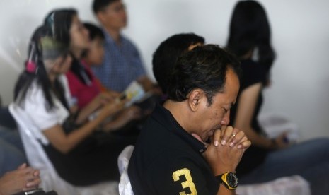 Kerabat korban AirAsia QZ8501 berdoa di gereja.