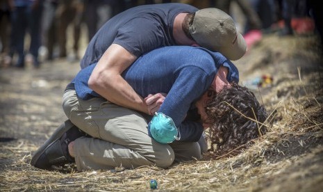 Kerabat korban jatuhnya pesawat Ethiopian Airlines Boeing 737 MAX 8 berduka di lokasi jatuhnya pesawat di Bishoftu, Addis Ababa, Etiopia, Rabu (13/3).