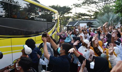 Kerabat melambaikan tangan pada jamaah calon haji di dalam bus saat pemberangkatan di Wisma Haji Kota Madiun, Jawa Timur, Selasa (7/6/2022). Sebanyak 90 orang jemaah calon haji dari Kota Madiun diberangkatkan menuju Asrama Haji Surabaya dan rencananya diterbangkan ke Tanah Suci pada Kamis (9/6). 