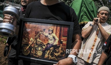 Kerabat membawa foto dan barbel selebriti almarhum Agung Santoso atau Agung Hercules saat akan dimakamkan di TPU Cikutra, Bandung, Jawa Barat, Jumat (2/8/2019). 