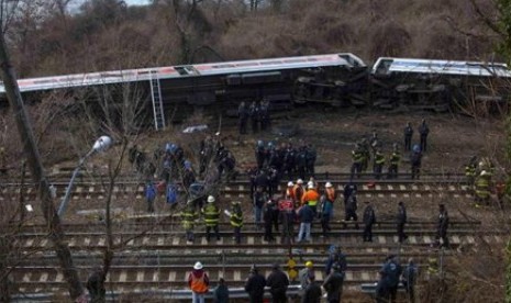  Petugas darurat berkumpul di lokasi tergelincirnya kereta api di Bronx, New York, Ahad (1/12). 