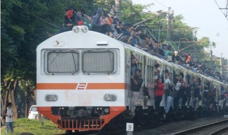 Para penumpang naik di atap kereta api Jabodetabek.