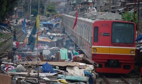   Kereta Api Listrik (KRL) melintas diantara bangunan kumuh di bantaran rel Kereta Api kawasan Senen, Jakarta Pusat, Senin (24/3).  (foto: Raisan Al Farisi)