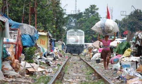   Kereta Api Listrik (KRL) melintas diantara bangunan kumuh di bantaran rel Kereta Api kawasan Senen, Jakarta Pusat, Senin (24/3).  (foto: Raisan Al Farisi)