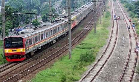 Kereta listrik melintas di samping jalur rel Double Double Track (DDT) yang sudah terpasang di kawasan Kalibaru, Bekasi, Jawa Barat, Jumat (11/3). 