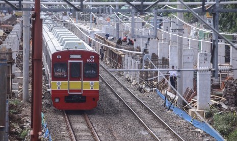 Kereta Rel Listrik (KRL) melaju di samping lokasi pembangunan Stasiun Sudirman Baru di Jakarta, Rabu (28/12). 