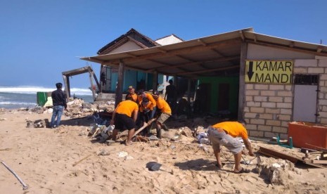 Kerja bakti masyarakat pesisir selatan di pantai-pantai Kabupaten Gunungkidul, Kamis (26/7) siang.  Masyarakat dan elemen-elemen kebencanaan membersihkan puing berserakan usai gelombang tinggi.