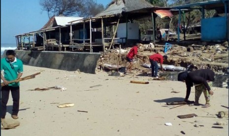 Kerja bakti masyarakat pesisir selatan di pantai-pantai Kabupaten Gunungkidul, Kamis (26/7) siang.  Masyarakat dan elemen-elemen kebencanaan membersihkan puing berserakan usai gelombang tinggi.