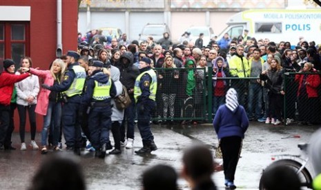 Kerumunan masa dekat lokasi penyerangan Sekolah Kronan di Trollhattan, Swedia, Kamis, 22 Oktober 2015.  