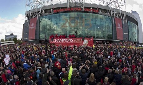 Kerumunan padat fans Manchester United mengelilingi bus terbuka di Old Traffrod yang membawa pemain MU berparade menuju Albert Square, Senin (13/5/2013)