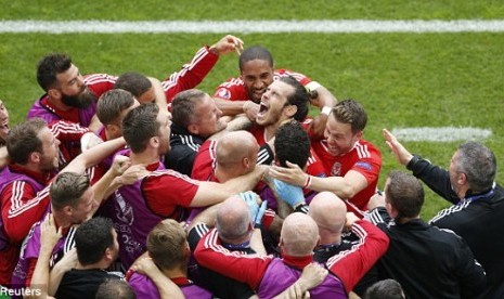 Kesebelasan Wales melakukan selebrasi usai sang bomber, Gareth Bale mencetak gol pembuka ke gawang Slovakia di laga perdana grup B Piala Eropa 2016, Sabtu (11/6) WIB.