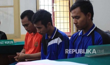 Ketiga terdakwa kasus pembunuhan sekeluarga Andi Lala (kiri), Andi Syahputra (tengah) dan Roni Anggara (kanan) mengikuti sidang dengan agenda tuntutan di Pengadilan Negeri Medan, Sumatera Utara, Jumat (29/12).