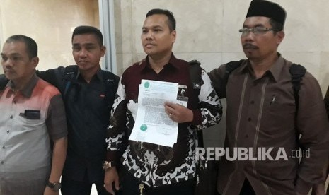 Ketua Aliansi Mitra Agen Jamaah Abu Tours, Muhammad Yusuf (memegang kertas) bersama jamaah lainnya meminta agar Kemenag tidak mencabut izin operasional Abu Tours di Gedung DPR RI, Selasa (27/3). 