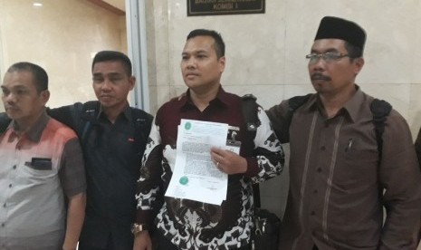 Ketua Aliansi Mitra Agen Jamaah Abu Tours, Muhammad Yusuf (memegang kertas) bersama jamaah lainnya meminta Kemenag tidak mencabut izin operasional Abu Tours di Gedung DPR RI, Selasa (27/3).