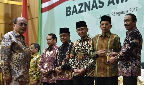 Ketua Badan Amil Zakat Nasional (BAZNAS) Bambang Sudibyo (kiri) bersama Sekjen Kemendagri Hadi Prabowo (kanan) menyerahkan penghargaan kepada Gubernur Nusa Tenggara Barat (NTB) Tuan Guru Bajang (TGB) Muhammad Zainul Majdi (kedua kanan), Wakil Gubernur Banten Hazrumy (ketiga kanan) dalam Baznas Award 2017 di Jakarta (Ilustrasi)