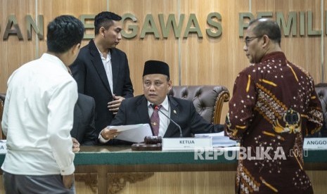 Ketua Badan Pengawas Pemilihan Umum (Bawaslu) Abhan (tengah) berbincang dengan Komisioner KPU Hasyim Asy'ari (kanan) dan Tim Kuasa Hukum Oso Gugum Ridho Putra (kiri) dalam sidang lanjutan dugaan pelangggaran administrasi terkait pencalonan Oesman Sapta Odang alias Oso sebagai anggota DPD, di Kantor Bawaslu, Jakarta, Rabu (2/1/2019). 