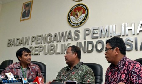 Ketua Badan Pengawas Pemilu (Bawaslu) Muhammad (tengah), Koordinator Indonesia Corruption Watch (ICW) Abdullah Dahlan (kanan), dan Koordinator Indonesia Budget Centre (IBC) Roy Salam (kiri) berbicara saat memberi laporan ke kantor Bawaslu, Jakarta, Jumat (