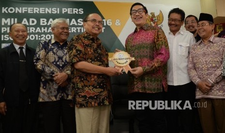 Ketua Baznas Bambang Sudibyo (ketiga kiri) menerima simbolis sertifikat ISO dari Lead Auditor WQA Novian AP (keempat kiri), serta didampingi sejumlah anggota Baznas saat acara Milad Ke-16 Baznas di kantor Baznas, Jakarta, Selasa (17/1).