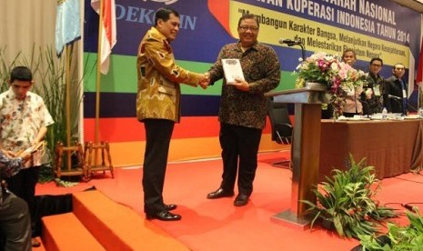 Ketua Dekopin Nurdin Halid (kiri) memberikan buku berjudul Koperasi Pilar Negara kepada Menteri Koperasi dan UKM AA Gede Ngurah Puspayofa