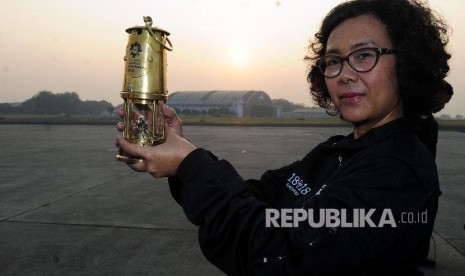 Ketua Delegasi Api Obor Celerina Judisari memperlihatkan alat untuk membawa api obor Asian Games 2018 usai acara pelepasan tim torch relay di Lanud AU Halim Perdana Kusuma, Jakarta, Sabtu (14/7). 