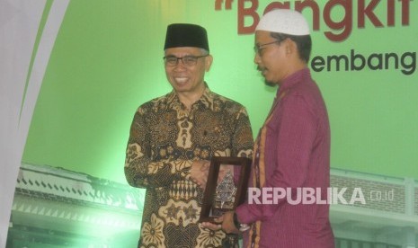 Ketua Dewan Komisioner OJK Wimboh Santoso (kiri) menyerahkan cinderamata saat meresmikan Bank Wakaf Mikro Bangkit Nusantara di Pondok Pesantren Roudlatut Thalibin, Rembang, Jawa Tengah, Kamis (9/1/2020). 