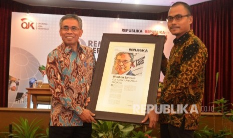 Ketua Dewan Komisioner OJK Wimboh Santoso (kiri0 menerima cinderamata dari Pemimpin Redaksi Repulika Irfan Junaidi saat pembukaan seminar Perbankan Syariah bertajuk Rembuk Republik, Jakarta, Kamis (5/10).