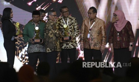 Ketua Dewan Komisioner Otoritas Jasa Keuangan (OJK) Wimboh Santoso (tengah) berfoto bersama dengan para penerima penghargaan TPKAD Award saat Rapat Koordinasi Nasional Tim Percepatan Akses Keuangan Daerah (TPAKD) dan Silahturahmi Nasional Bank Wakaf Mikro 2019 di Jakarta, Selasa (10/12/2019). 