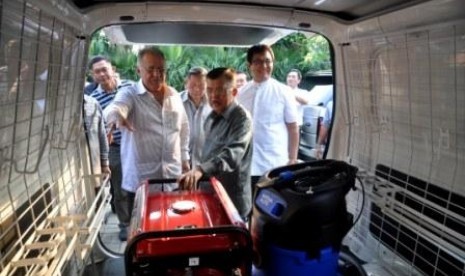 Ketua Dewan masjid Indonesia Jusuf Kalla (kedua dari kiri) bersama Donatur mobil pembersih sekaligus pemilik yayasan Haji Anif(kiri) meninjau mobil pembersih dan perawatan masjid gratis di kantor sekertariat Dewan masjid, Jakarta, Jumat (4/10).