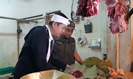 Ketua DPD Golkar Jabar yang juga mantan Bupati Purwakarta, Dedi Mulyadi, saat membeli daging sapi di Pasar Leuwi Panjang, dengan membawa sendiri daun jati dan ikat bambunya, Ahad (4/8).