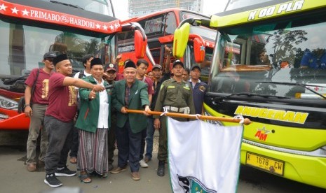 Ketua DPP PKB KH Saifullah Maksum mengibarkan bendera sebagai tanda pemberangkatan mudik gratis bersama PKB di pelataran Taman Ismail Marzuki Jakarta, (22/6)