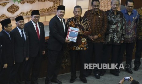 Ketua DPR Bambang Soesatyo (keempat kiri) berjabat tangan dengan Ketua BPK Moermahadi Soerja Djanegara (keempat kanan) saat menerima hasil laporan BPK pada Rapat Paripurna DPR di Kompleks Parlemen Senayan, Jakarta, Kamis (31/5).